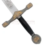 Close-up of King Arthur's Excalibur replica handle and pommel with black grip, engraved fittings, and medieval crest design.